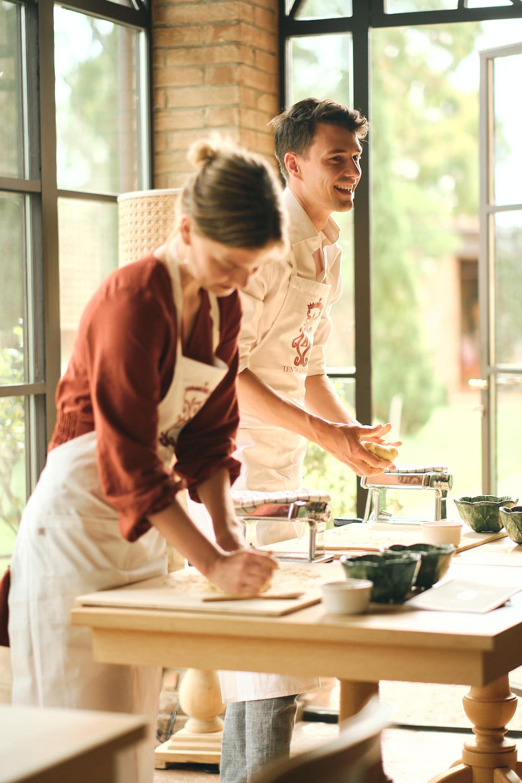 Guests making pasta together in a cooking class, sunlit room