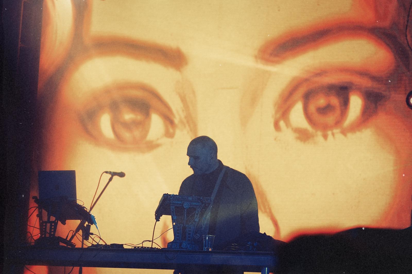 A performer silhouetted against a huge projected eyes visual