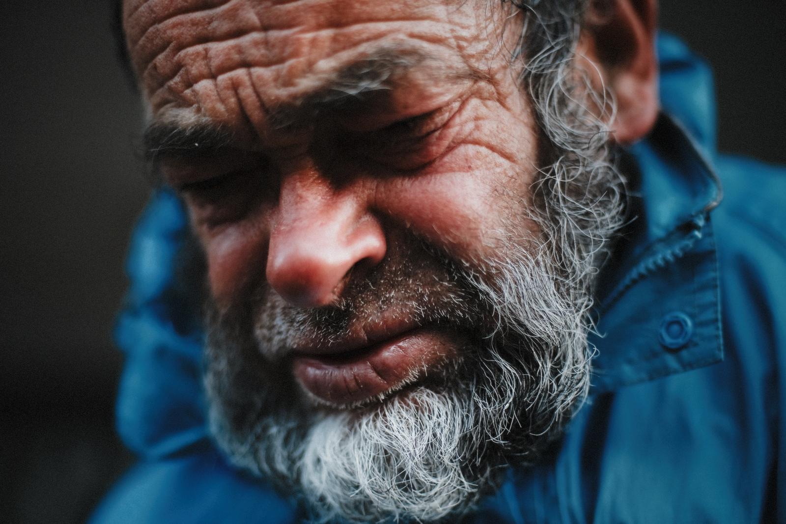 The man's face lit warmly from one side, eyes closed or lowered