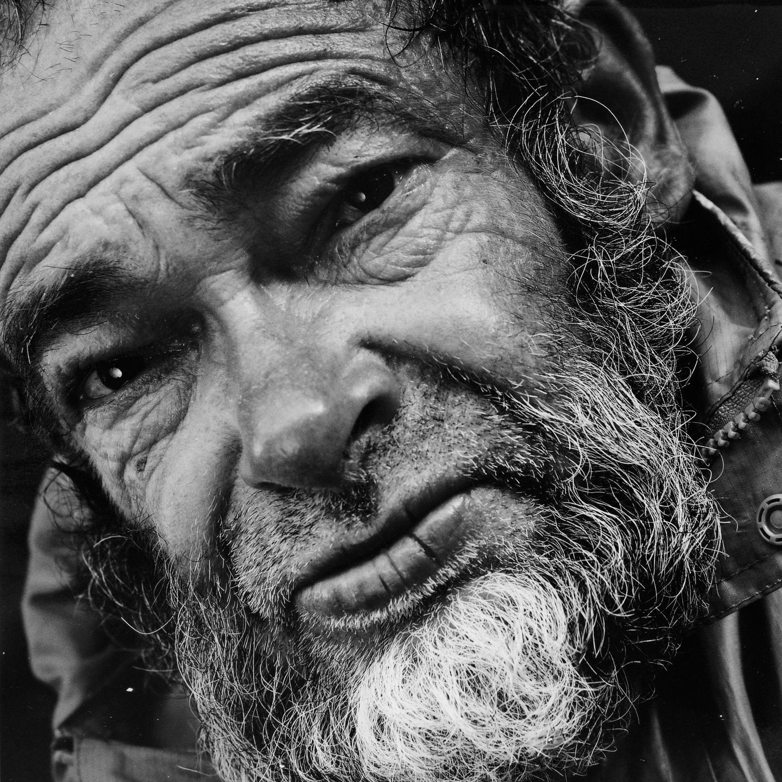 Black and white square portrait of the man's face, angled, looking at the camera