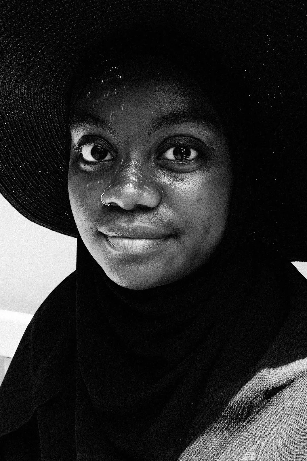 Close portrait of a woman in a wide-brimmed hat and headscarf, smiling, Marrakesh