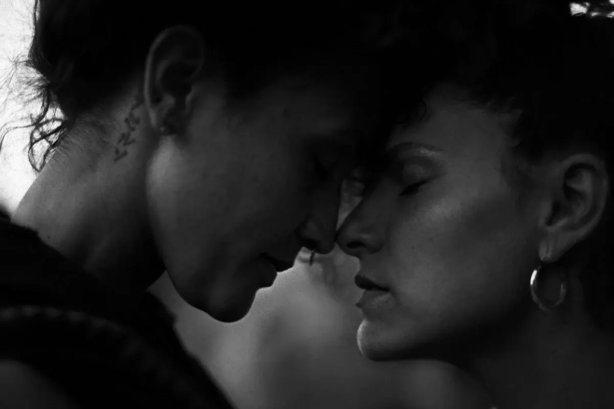 Two women standing forehead to forehead, eyes closed, black and white