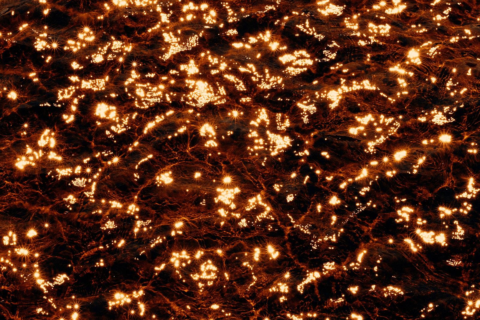 Sunlight scattered across the dark tannin-stained water of a tea tree lake