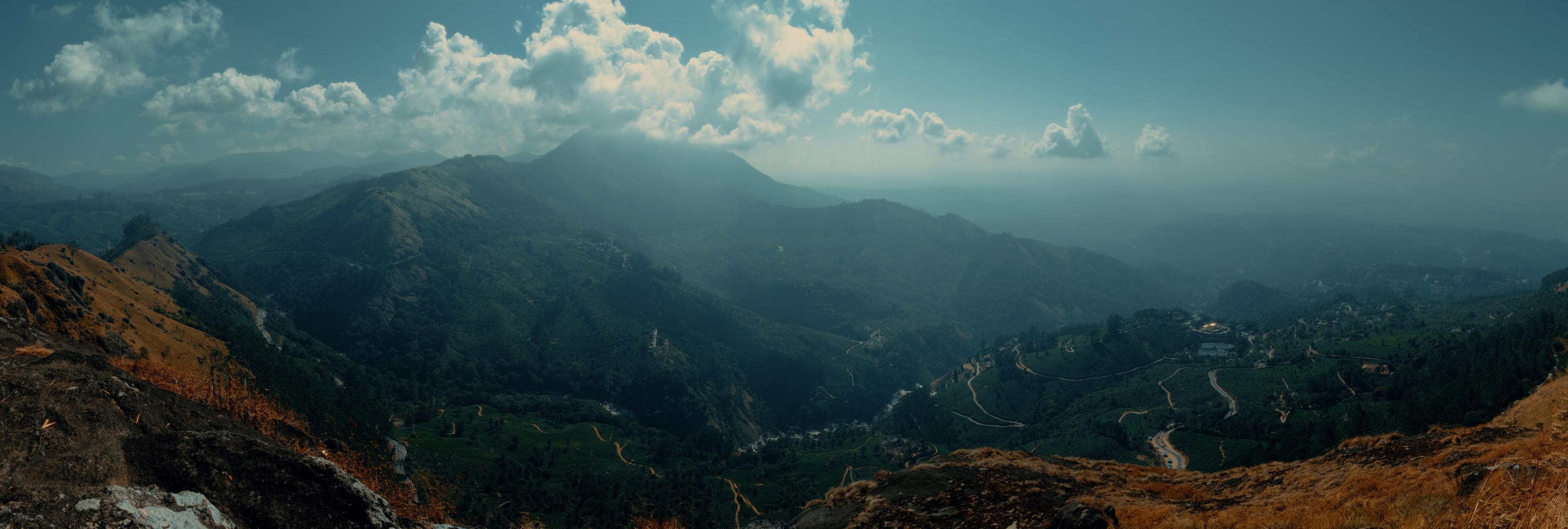 A wide panorama over the valley and its winding roads, seen from the ridge