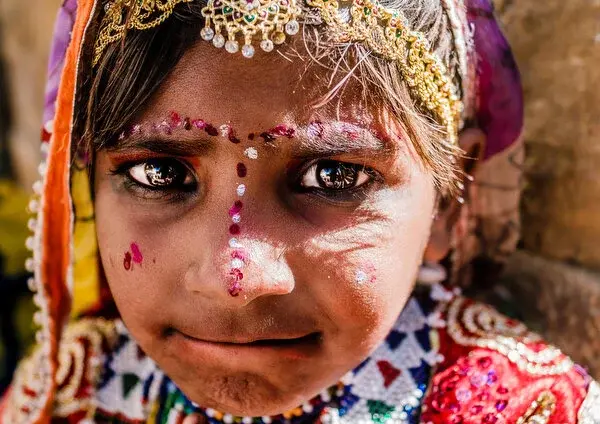 Close portrait of a girl in ornate festival dress and jewellery, direct gaze