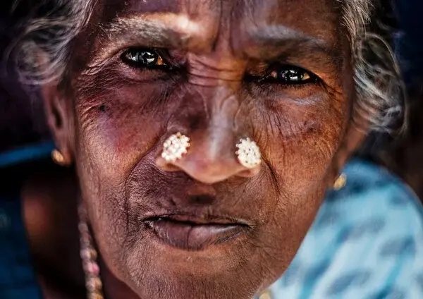 Close portrait of an elderly woman with nose studs, in Munnar, Kerala